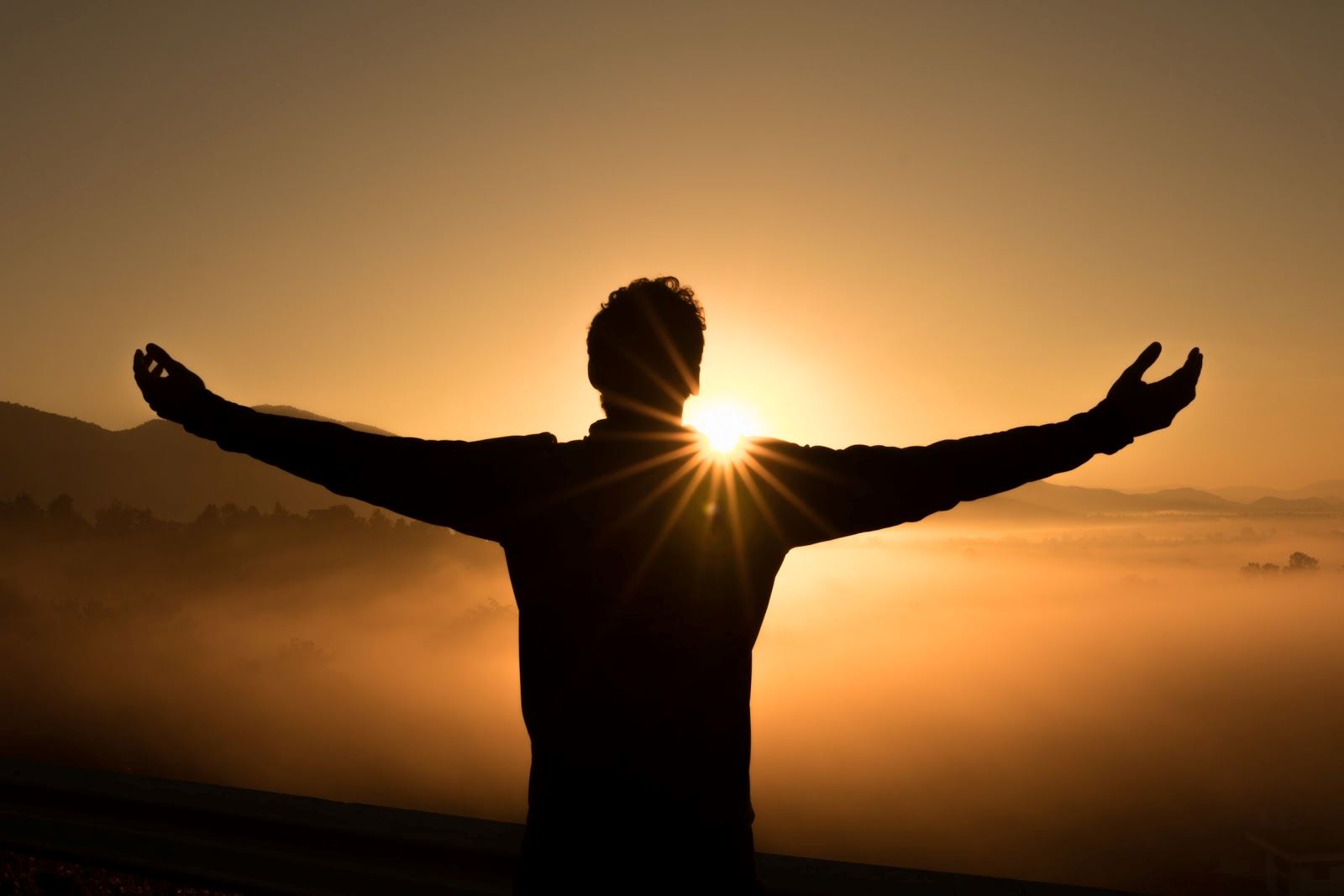 Silhouette of man against golden sunset