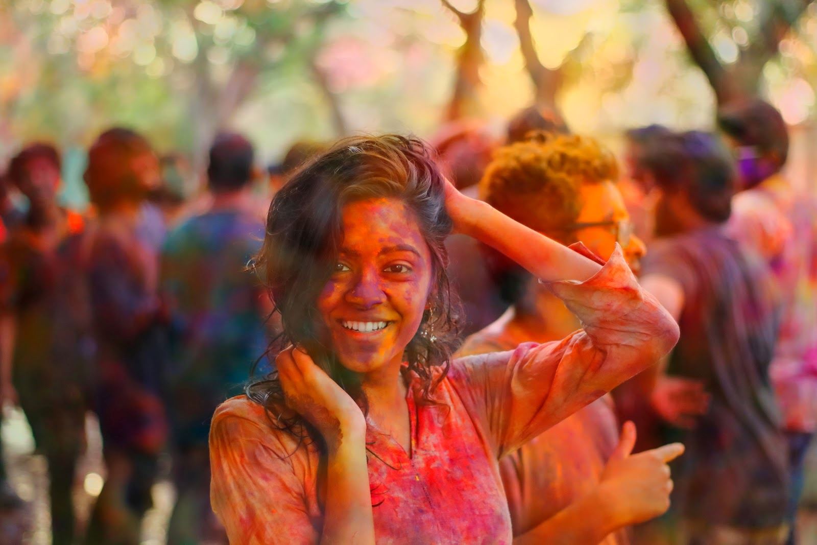 A young woman at a paint party, covered in red powder paint