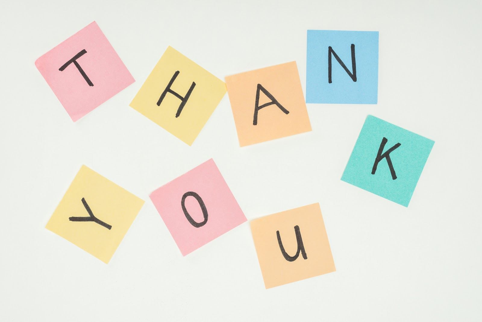 Individual letters on different coloured squares, spelling “thank you”